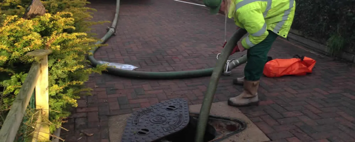Septic tank cleaning technician servicing a septic tank with a vacuum hose in Clearwater, FL