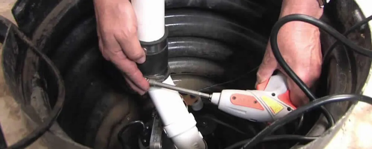 Sump pump installation technician connecting PVC discharge piping in Clearwater, FL